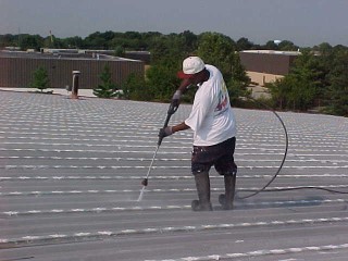 Pressure washing by Roof Menders' crew member
